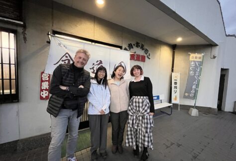 Mark Cummings standing with three members of the Walk Japan team outside a restaurant in Japan.
