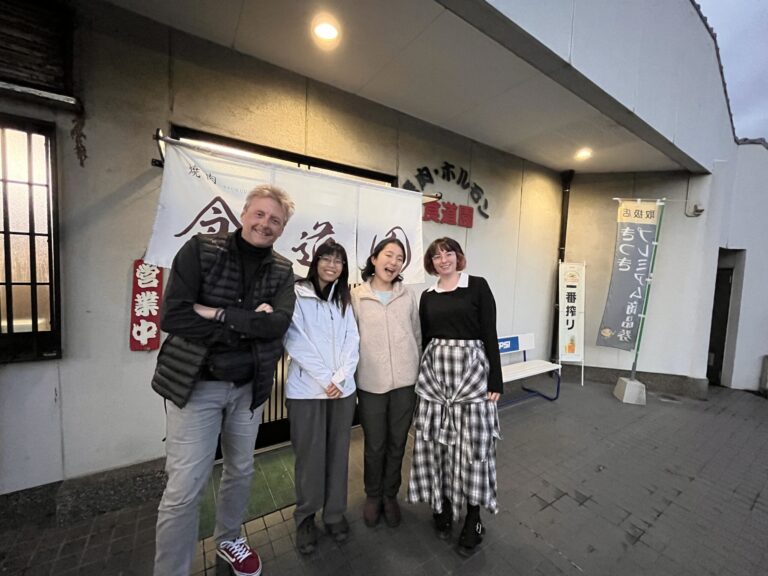 Mark Cummings standing with three members of the Walk Japan team outside a restaurant in Japan.