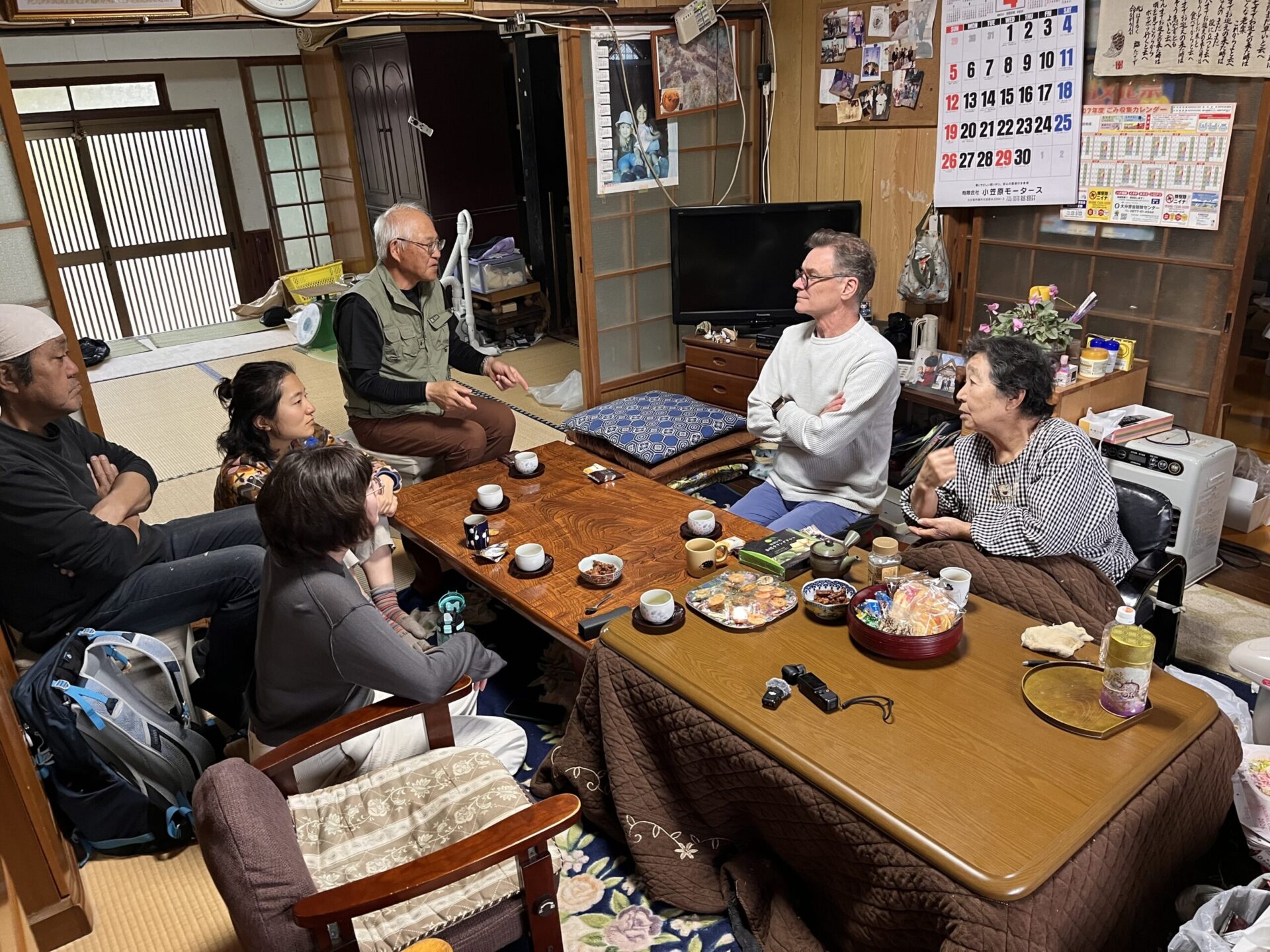 Paul Christie and visitors sharing tea and conversation with Etchan around a table in her Japanese home.
